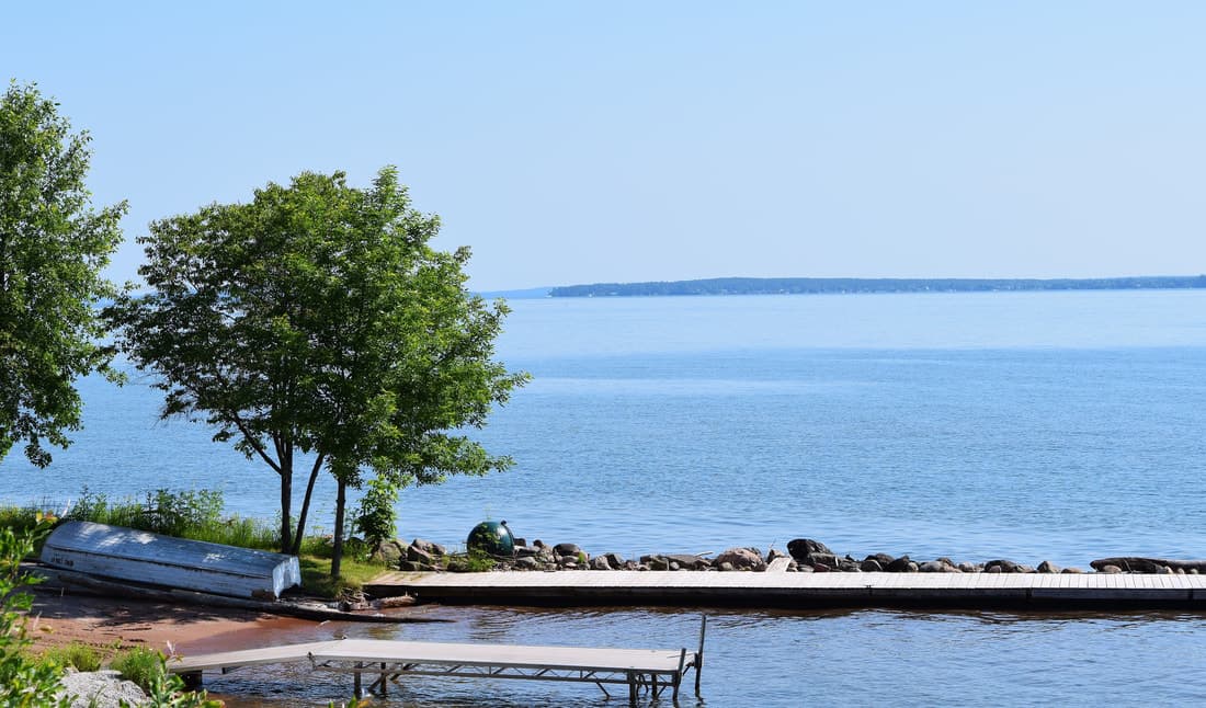 Docks and a rowboat on the shore, with an Apostle Island across the water
